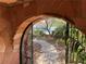 Close up of stone archway at the entrance, offering a glimpse of the walkway and lush greenery ahead at 3167 El Cedro Cir, Las Vegas, NV 89121