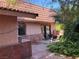 Exterior view of the house featuring flagstone accents, tile roof, and a cozy patio with seating, blending indoor-outdoor living at 3167 El Cedro Cir, Las Vegas, NV 89121