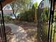 View of the front yard featuring trees and a gate with a pathway to the house at 3167 El Cedro Cir, Las Vegas, NV 89121