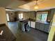 View of kitchen featuring an island with black countertops, grey cabinets and stone walls at 3167 El Cedro Cir, Las Vegas, NV 89121