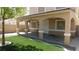 Inviting backyard featuring artificial grass, concrete patio, and charming string lights at 3606 Gold Sluice Ave, North Las Vegas, NV 89032