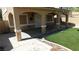Spacious backyard with artificial grass, concrete patio, and covered porch at 3606 Gold Sluice Ave, North Las Vegas, NV 89032
