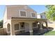 Tan two-story home featuring a covered porch adorned with decorative string lights at 3606 Gold Sluice Ave, North Las Vegas, NV 89032