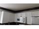 Kitchen with white cabinets, a microwave, stainless steel refrigerator, and mosaic backsplash at 3606 Gold Sluice Ave, North Las Vegas, NV 89032