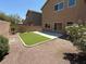 Landscaped backyard with artificial turf, concrete patio, desert landscaping, and block wall at 3736 Gallowtree Ave, North Las Vegas, NV 89081
