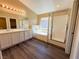 Well-lit bathroom with double vanity, soaking tub, and glass-enclosed shower at 3736 Gallowtree Ave, North Las Vegas, NV 89081