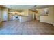 Open-concept kitchen and living area with white cabinets, breakfast bar, and tiled flooring at 3736 Gallowtree Ave, North Las Vegas, NV 89081