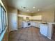 Bright kitchen with white cabinets, modern appliances, breakfast bar, and tiled flooring at 3736 Gallowtree Ave, North Las Vegas, NV 89081