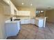 Bright kitchen with white cabinets, modern appliances, breakfast bar, and tiled flooring at 3736 Gallowtree Ave, North Las Vegas, NV 89081