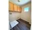 Functional laundry room with overhead cabinets, wood floors, and a bright window at 3736 Gallowtree Ave, North Las Vegas, NV 89081