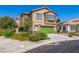 Charming two-story home featuring stone accents, a green garage door, and well-manicured landscaping at 4415 Peaceful Harbor St, Las Vegas, NV 89129