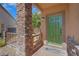Welcoming front entry with stone pillar, wooden accent fence, and stylish green front door at 4415 Peaceful Harbor St, Las Vegas, NV 89129