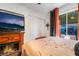 Bedroom with a fireplace, TV, and view to the pool at 444 Viewmont Dr, Henderson, NV 89015