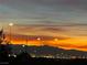 Breathtaking sunset view of the city skyline with mountains, streetlights, and colorful clouds at 444 Viewmont Dr, Henderson, NV 89015