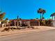 Desert-style home featuring a Spanish-tile roof, mature palms, and a two-car brown garage door at 444 Viewmont Dr, Henderson, NV 89015