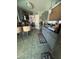Gray kitchen features tile flooring, island seating and stainless steel dishwasher and a view to the dining area at 444 Viewmont Dr, Henderson, NV 89015