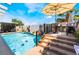Outdoor living space featuring a refreshing pool, poolside seating, and lush greenery at 444 Viewmont Dr, Henderson, NV 89015