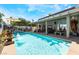 Sparkling pool with waterfall feature, adjacent to a covered patio and outdoor seating area at 444 Viewmont Dr, Henderson, NV 89015