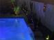 Backyard pool area with waterfall feature, desert landscaping, and accent lighting for nighttime ambiance at 444 Viewmont Dr, Henderson, NV 89015