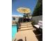 Outdoor dining area beside a pool with a patio umbrella, potted plants, and built-in bar seating at 444 Viewmont Dr, Henderson, NV 89015
