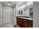 Bright bathroom featuring double sinks with dark wood cabinets and tile floors at 51 Morning Mimosa Ct, Henderson, NV 89012
