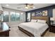 Cozy bedroom featuring plush carpeting, a ceiling fan, and an abundance of natural light from the large windows at 51 Morning Mimosa Ct, Henderson, NV 89012