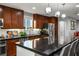 Modern kitchen featuring dark wood cabinets, stainless steel appliances, and a large black countertop island at 51 Morning Mimosa Ct, Henderson, NV 89012