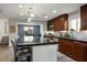 Open kitchen with dark wood cabinets, stainless steel appliances, large island with seating, and dining area view at 51 Morning Mimosa Ct, Henderson, NV 89012
