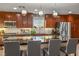 Modern kitchen featuring dark wood cabinets, stainless steel appliances, and a large black countertop island at 51 Morning Mimosa Ct, Henderson, NV 89012