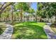 Exterior view of the property featuring lush landscaping, a sidewalk and well-maintained grassy areas at 5196 Mandalay Springs Dr # 101, Las Vegas, NV 89120