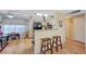 Open concept kitchen featuring breakfast bar, light wood cabinets, and modern appliances at 5196 Mandalay Springs Dr # 101, Las Vegas, NV 89120