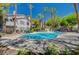 Resort-style community pool surrounded by palm trees and patio furniture at 5196 Mandalay Springs Dr # 101, Las Vegas, NV 89120