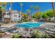 Resort-style community pool surrounded by palm trees and patio furniture at 5196 Mandalay Springs Dr # 101, Las Vegas, NV 89120