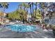 A community pool surrounded by lounge chairs, palm trees and patio furniture at 5196 Mandalay Springs Dr # 101, Las Vegas, NV 89120