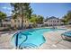 Community pool surrounded by lounge chairs, palm trees and patio furniture at 5196 Mandalay Springs Dr # 101, Las Vegas, NV 89120