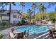 The sparkling community pool with surrounding seating, lush landscaping, and shade trees at 5196 Mandalay Springs Dr # 101, Las Vegas, NV 89120
