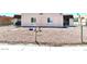 A small, single-story home with light stucco walls and a gravel front yard enclosed by a chain-link fence at 5305 W Cheyenne Ave, Las Vegas, NV 89108
