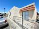 Side view of small apartment building with light-colored stucco, security fencing, and individual covered patios at 5305 W Cheyenne Ave, Las Vegas, NV 89108