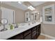 Bathroom featuring double sinks, dark wood cabinets, and shuttered windows at 5542 Oak Bend Dr, Las Vegas, NV 89135
