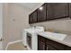 Functional laundry room equipped with washer, dryer, sink and built-in cabinets at 5542 Oak Bend Dr, Las Vegas, NV 89135