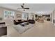 Open-concept living room featuring tile floors, a ceiling fan, and abundant natural light from plantation shuttered windows at 5542 Oak Bend Dr, Las Vegas, NV 89135