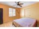 Bedroom with fan, window, and closet boasts hardwood floors and warm, inviting wall color at 6058 Grape Blossom Ave, Las Vegas, NV 89142