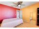 Bedroom features an eclectic color scheme, wood floors, a ceiling fan and closet at 6058 Grape Blossom Ave, Las Vegas, NV 89142