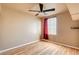 Bright bedroom featuring hardwood floors, ceiling fan, and a window with red curtains at 6058 Grape Blossom Ave, Las Vegas, NV 89142