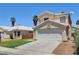 Inviting two-story house with a two car garage, a long driveway, palm trees and desert landscaping at 6058 Grape Blossom Ave, Las Vegas, NV 89142
