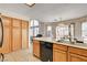 Open kitchen, featuring tile floors, wood cabinets, plenty of windows and a view into the living room at 6058 Grape Blossom Ave, Las Vegas, NV 89142