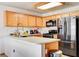 Bright kitchen featuring stainless steel appliances, wood cabinets and a breakfast bar at 6058 Grape Blossom Ave, Las Vegas, NV 89142