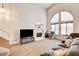 Bright living room featuring a fireplace, large windows and neutral carpet at 6058 Grape Blossom Ave, Las Vegas, NV 89142