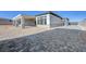 Backyard showing covered patio, the exterior of the house, and a large empty space at 6075 Dapple Gray Rd, Las Vegas, NV 89149