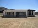 Backyard view of a modern home with large windows and an open patio area, showing the spacious lot at 6075 Dapple Gray Rd, Las Vegas, NV 89149